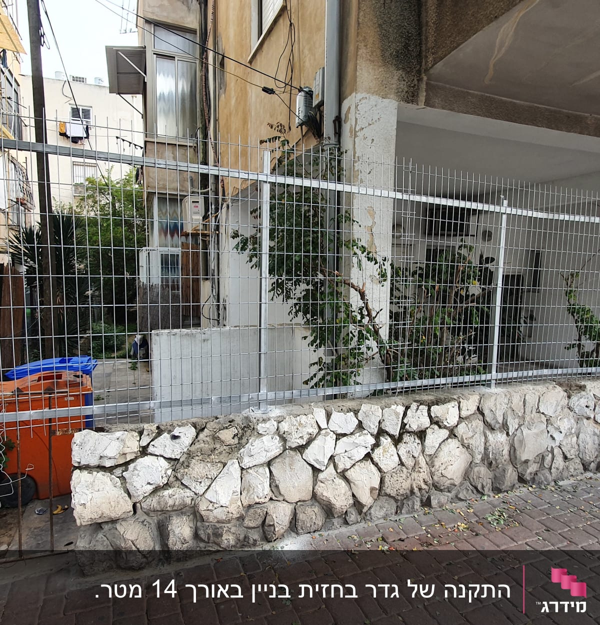 גדר מתכת עם מסגרת אבן על מדרכה